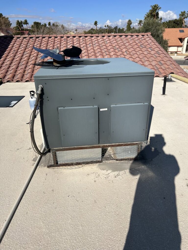 A rooftop HVAC unit installed by Usa Air Conditioning & Heating, with a technician's shadow, in Las Vegas, NV