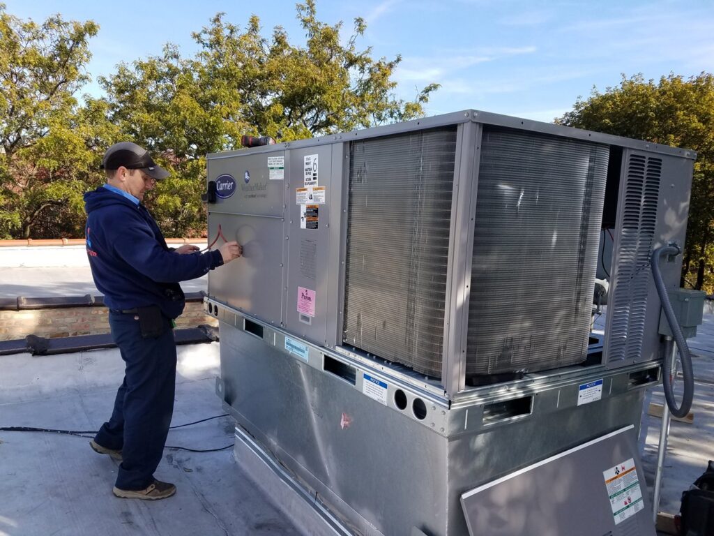 A Service Pro Titans technician performing maintenance on a large Carrier rooftop HVAC unit in Chicago, IL.