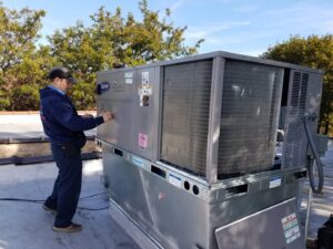 A Service Pro Titans technician performing maintenance on a large Carrier rooftop HVAC unit in Chicago, IL.