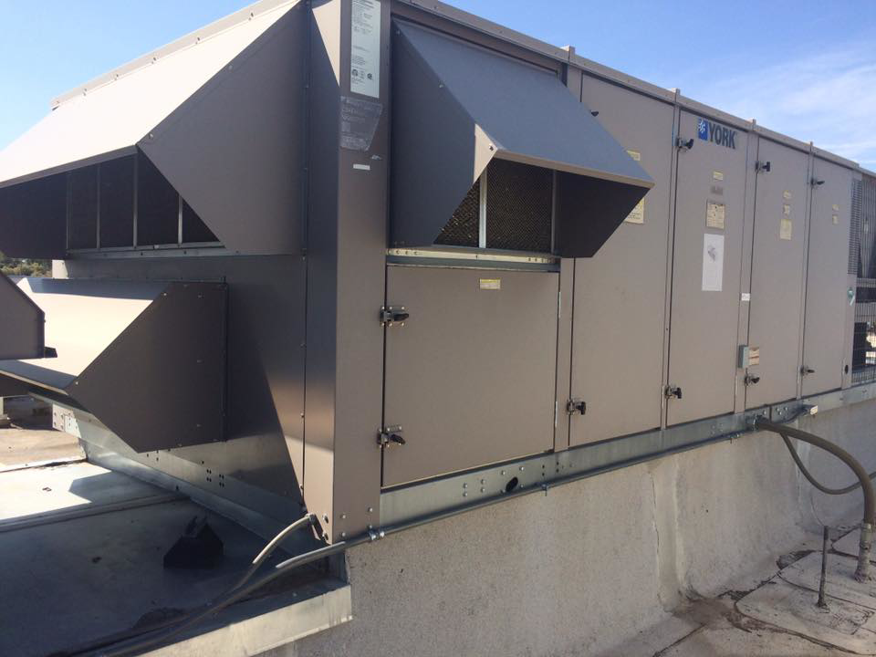 A large commercial rooftop HVAC unit being maintained by Juan Tabo Heating & Cooling Maintenance in Albuquerque, NM.