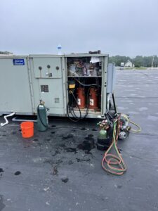 A rooftop American Standard HVAC unit undergoing repair or maintenance with tools and equipment by Advanced Comfort LLC in Concord, NH.