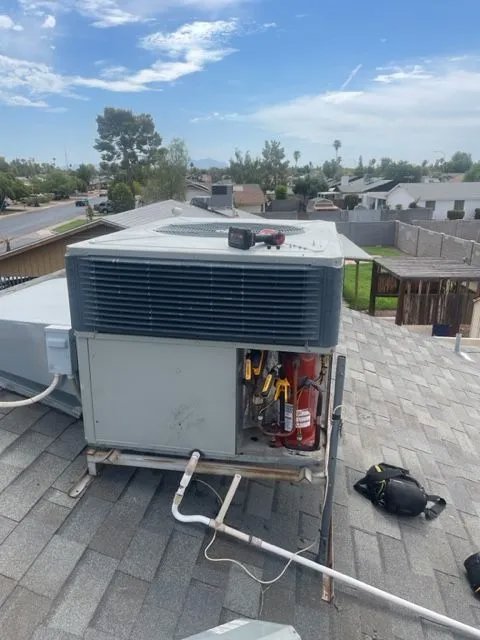 A rooftop HVAC unit with an open panel and tools, indicating repair work in progress by Ault's Cooling HVAC Services LLC in Chandler, AZ.