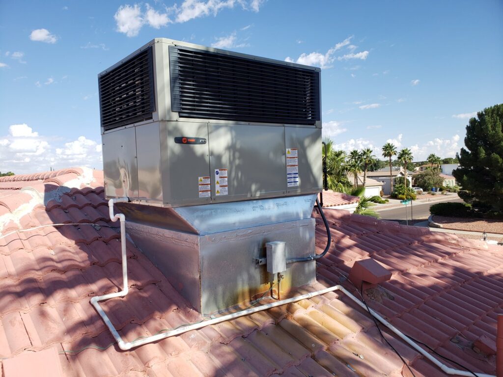 A rooftop HVAC unit installed on a residential red tile roof by Dynamic Heating, Cooling, Refrigeration & Roofing in El Paso, TX.