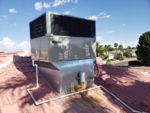 A rooftop HVAC unit installed on a residential red tile roof by Dynamic Heating, Cooling, Refrigeration & Roofing in El Paso, TX.