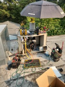 A Nelke Mechanical technician performing service and repair on a commercial rooftop HVAC unit in Keizer, OR.