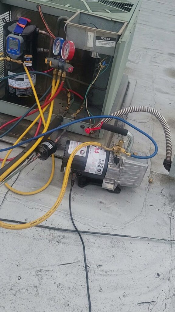 A rooftop HVAC unit being serviced with gauges and a vacuum pump by Brothers Heating & Cooling Inc. in Chicago, IL.