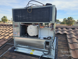A rooftop HVAC unit with its access panel open, showing internal components during service by Tanana Air Conditioning & Heating in Las Vegas, NV.