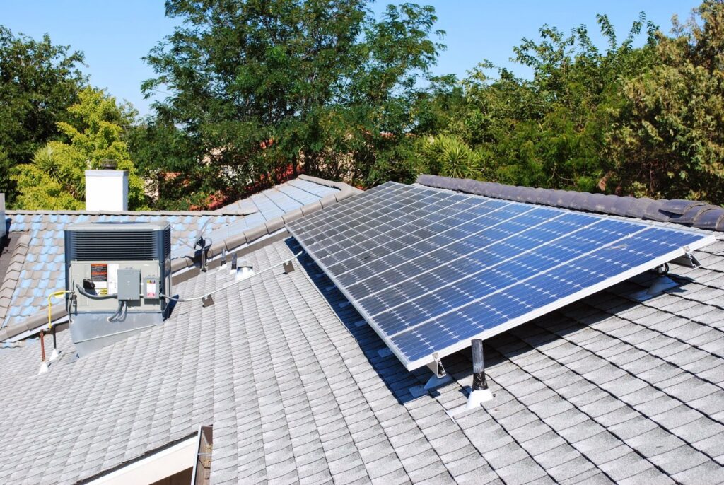 A rooftop HVAC unit installed next to solar panels by ALL YEAR Heating, Air and Solar in Sacramento, CA.