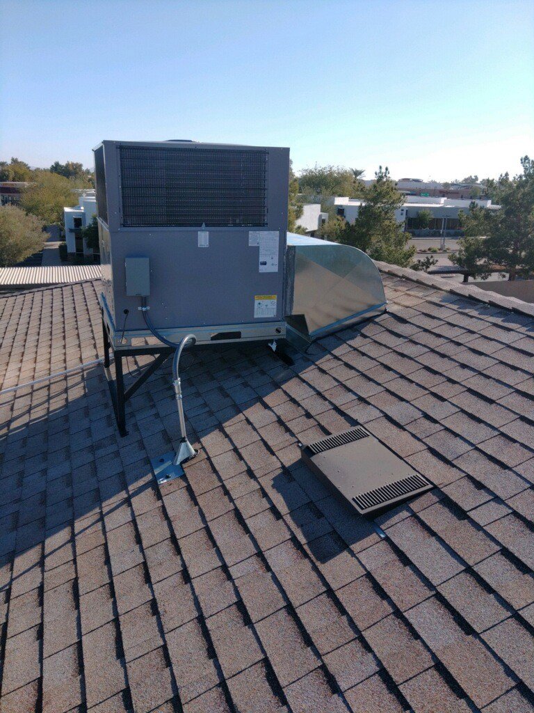 A rooftop HVAC unit with new ductwork installed on a shingled roof by Desert Heroes HVAC in Phoenix, AZ