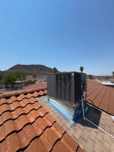 A rooftop HVAC unit installed on a residential tiled roof with a mountain view by Cool Camel HVAC in Henderson, NV