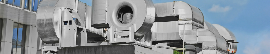 Large rooftop HVAC units and ductwork on a commercial building, serviced by Smith Heating and Cooling LLC in Ellensburg, WA.