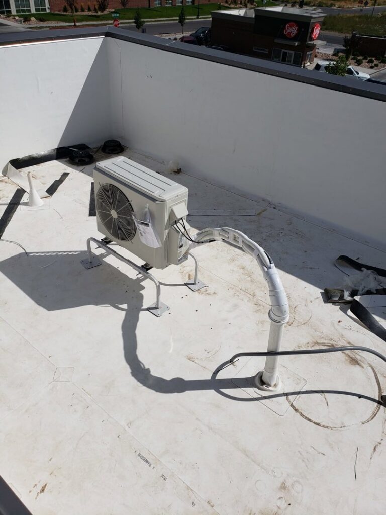 A mini-split air conditioning condenser unit installed on a rooftop by ABT Heating and Cooling in Orem, UT.