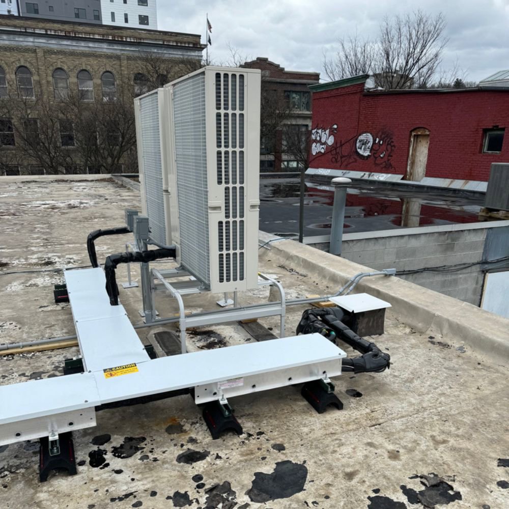 Multiple Mitsubishi Electric HVAC units installed on a commercial rooftop by Simply Installs Heating & Air Conditioning in Shortsville, NY.