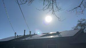 Solar panels installed on a residential rooftop, gleaming under a bright sun, by Pueblo Electrics, Inc. in Pueblo, CO.