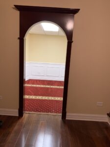 View through a doorway into a room with red patterned carpet installed by Musalla Masjid Carpets in Glendale Heights, IL.