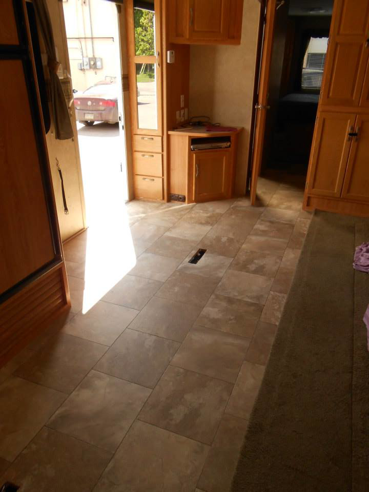 A room featuring new tile-patterned vinyl flooring transitioning to carpet, installed by Frosty's Carpet Center, Inc. in Grand Forks, ND.