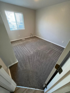A room featuring freshly cleaned grey carpet with visible vacuum lines, demonstrating the professional service of Sawtooth Carpet Cleaning in Nampa, ID.