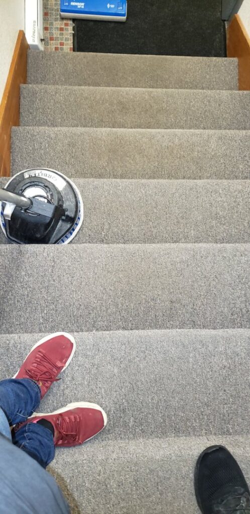 A rotary carpet cleaning machine being used on carpeted stairs by a professional from Alaska Dry Carpet in Anchorage, AK.