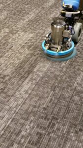 A rotary carpet cleaning machine in operation, deep cleaning a patterned carpet for Carpet Care in Reisterstown, MD.
