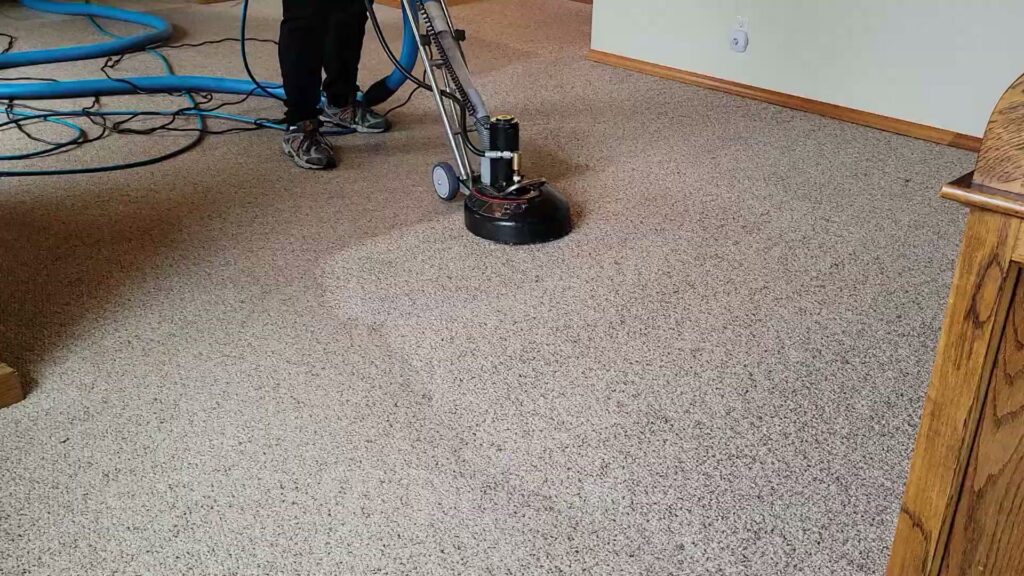 A professional operating a rotary carpet cleaning machine on a light-colored carpet by Mr. Suds Carpet Cleaning LLC in Coeur d'Alene, ID.