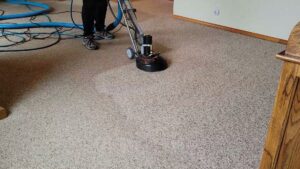 A professional operating a rotary carpet cleaning machine on a light-colored carpet by Mr. Suds Carpet Cleaning LLC in Coeur d'Alene, ID.
