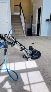 A rotary carpet cleaning machine with hoses in use on a carpeted floor by Pronto And Carpet LLC in Charlotte, NC.