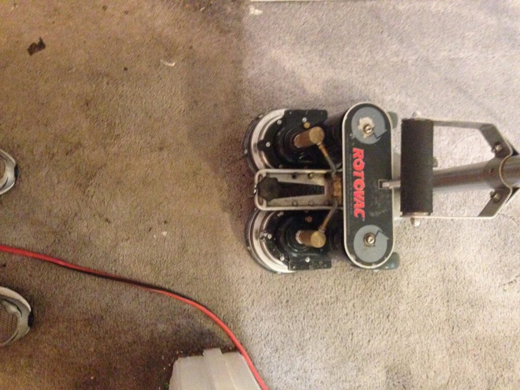 A Rotovac machine cleaning carpet, showing a clear line between cleaned and uncleaned areas by All Steamed Up Carpet/Upholstery Cleaning in Havana, FL