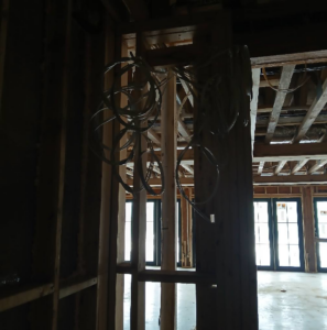 Essential Electric LLC installing rough-in electrical wiring in a framed wall during a project in Lancaster, KY.