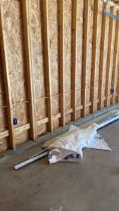 Rough-in electrical wiring and blue outlet boxes installed in a framed wall by AHM ELECTRIC in Houston, TX.