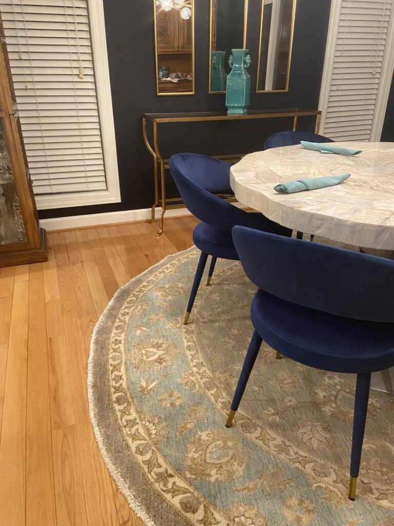 A round oriental rug complementing a modern dining area, provided by J and J Oriental Rug Gallery in Alexandria, VA.