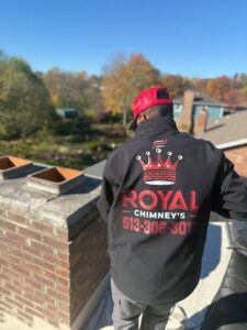 A Royal Chimney's technician on a roof inspecting a chimney in Blue Ash, OH.