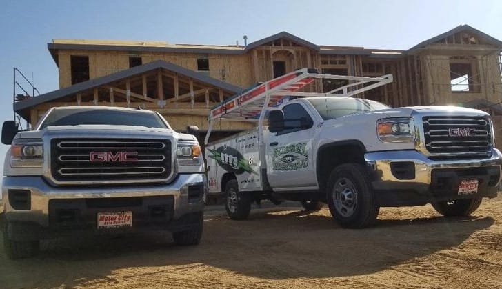 Two Ruebel Electric service trucks parked at a new home construction site in Bakersfield, CA.