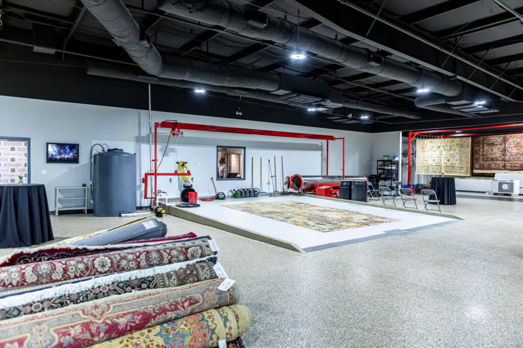 An indoor rug cleaning facility with professional equipment and rolled rugs at Mussallem Area Rug Specialist in Jacksonville, FL.