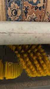 A close-up view of the rotating brush on a rug cleaning machine at Advanced Cleaning Systems in Atlanta, GA.