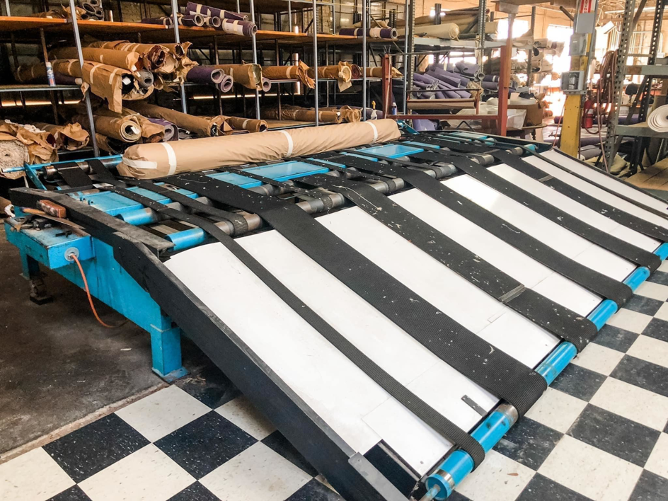 Interior of rug cleaning and restoration facility at George Bell Rug Cleaning & Restoration in Jackson, MS, with equipment and rolled rugs.