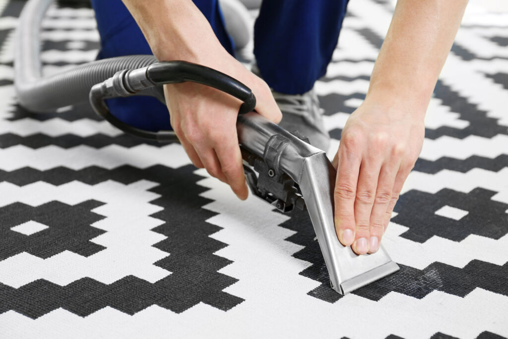 A professional from Chem-Dry Nona performing a detailed cleaning service on a black and white patterned rug in Orlando, FL.