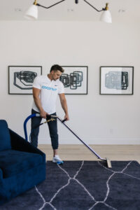 A professional performing a rug cleaning service for a client by Coconut Cleaning of Dallas-Fort Worth in Dallas, TX.