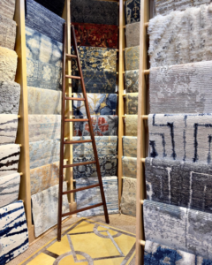 An interior view of the David Alan Rugs store in Austin, TX, showing a wide selection of rugs displayed on racks.
