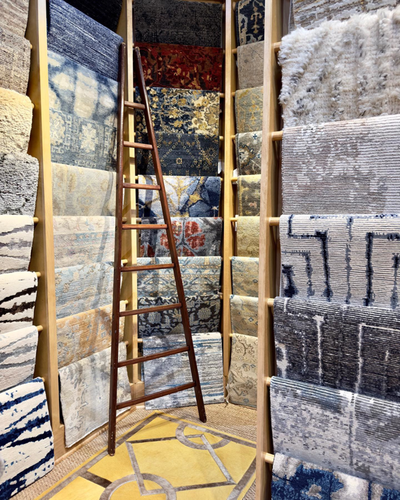 An interior view of the David Alan Rugs store in Austin, TX, showing a wide selection of rugs displayed on racks.