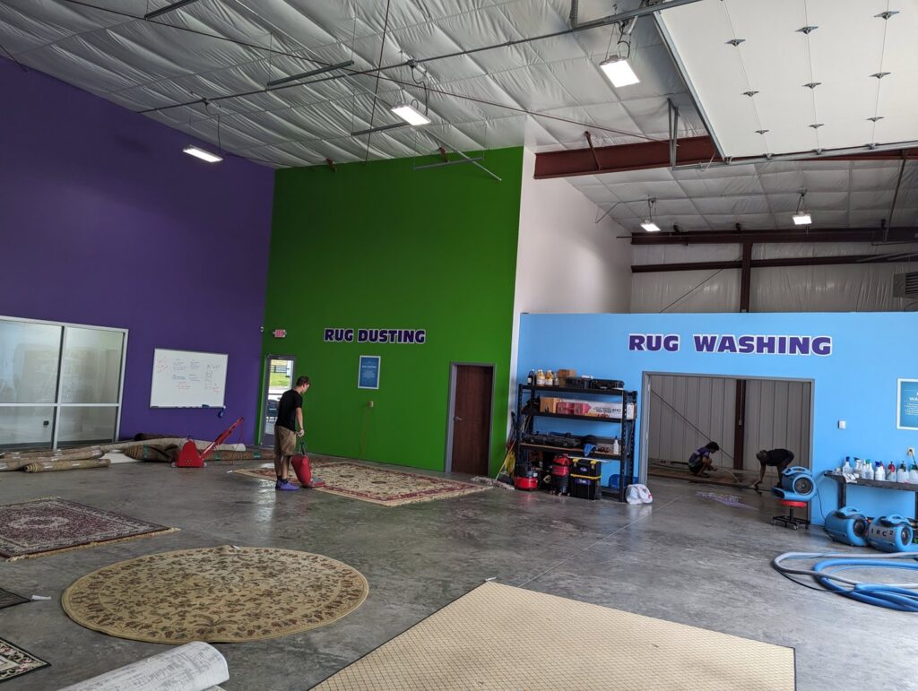 A rug dusting and washing facility with a technician working at The Carpet Chemist in Louisville, KY.