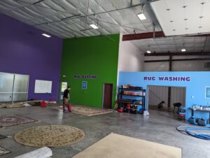 A rug dusting and washing facility with a technician working at The Carpet Chemist in Louisville, KY.