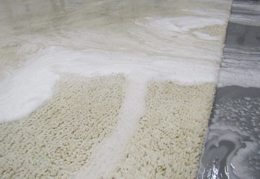 Staff inspecting a rug with a customer during a consultation at American Rug Laundry in Saint Paul, MN.