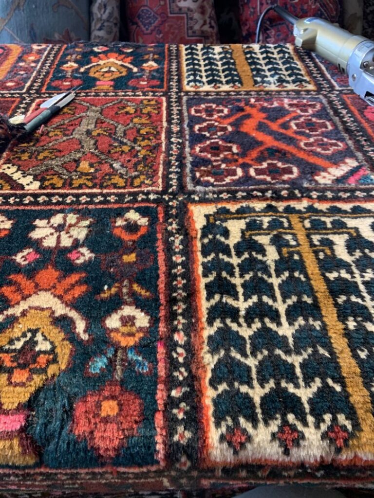 Close-up of a rug with tools, indicating repair or customization work by Danvers Rug in Danvers, MA.