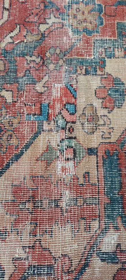 Close-up of a damaged rug showing patchwork repair by George Bell Rug Cleaning & Restoration in Jackson, MS.