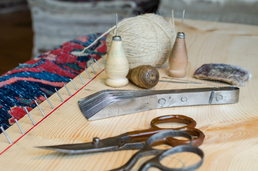 Rug repair and restoration tools, including needles, thread, and scissors, at George Bell Rug Cleaning & Restoration in Jackson, MS.