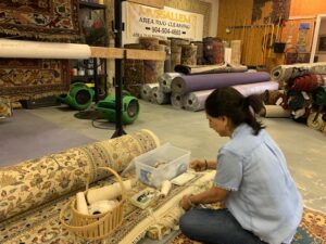 A rug repair specialist meticulously working on rug fringe repair at Mussallem Area Rug Specialist in Jacksonville, FL.