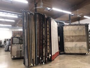 Interior view of the rug showroom with many rugs on display at Artifacts Fine Rugs and Flooring in South Salt Lake, UT.