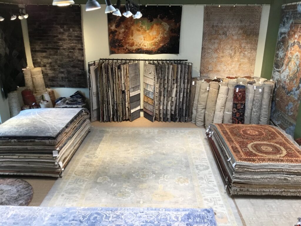An expansive interior view of the rug showroom at David Alan Rugs in Austin, TX, featuring various rug displays.