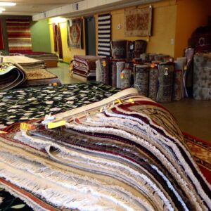 A rug being fed into a professional rug washing machine at American Rug Laundry in Saint Paul, MN.