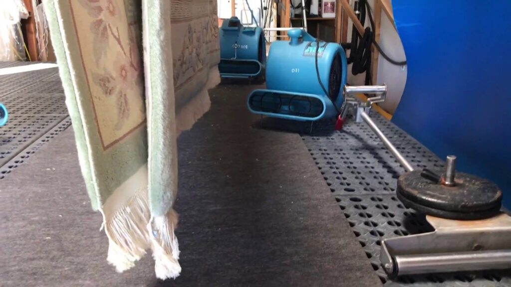 Multiple rugs hanging to dry with industrial air movers in the Rug Renew facility in Spring Valley, CA.